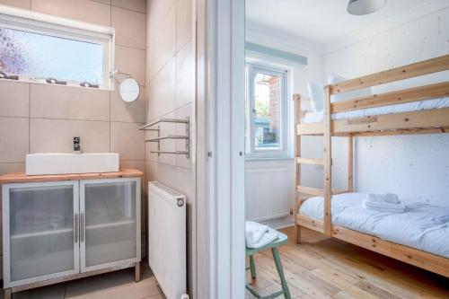 a small room with a bunk bed and a sink at Cosy Cottage - 2 Bedroom Cottage - Mumbles in Swansea