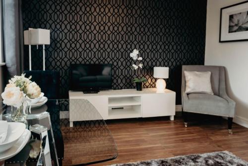 a living room with a white table and a chair at Hinckley Flats in Hinckley