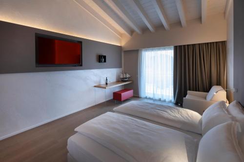 a bedroom with a bed and a tv on a wall at Locanda Monte Baldo in Malcesine