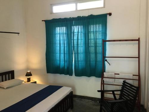 a bedroom with a bed and a blue curtain at Colombo Beach Hostel in Mount Lavinia