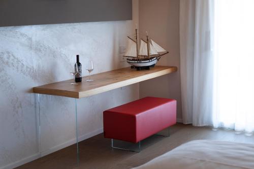 a shelf with a bottle of wine and a red stool at Locanda Monte Baldo in Malcesine