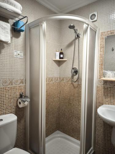 a bathroom with a shower and a toilet and a sink at Hostería VISTAPARK in El Astillero