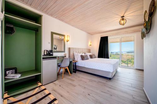 a hotel room with a bed and a desk and a kitchen at Leonidas Resort in Ermioni