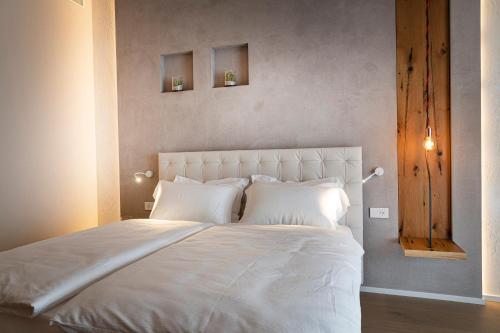 a white bed with white pillows in a bedroom at Locanda Monte Baldo in Malcesine