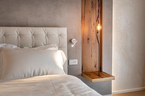 a bedroom with a white bed and a lamp at Locanda Monte Baldo in Malcesine