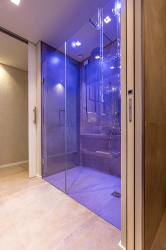 a bathroom with a glass shower with blue lighting at Locanda Monte Baldo in Malcesine