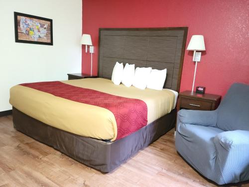 a hotel room with a bed and a chair at Econo Lodge Oacoma - Chamberlain West in Oacoma