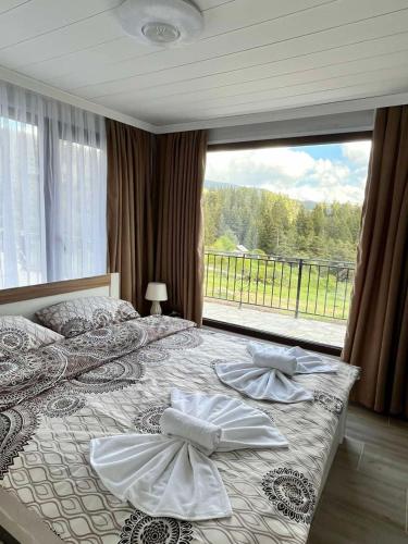 a bedroom with a bed with a large window at SAFI FOREST village in Dospat