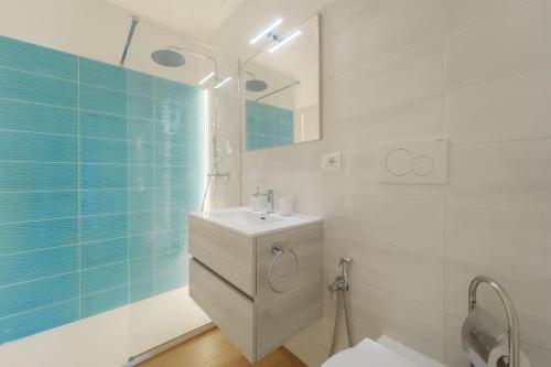 a white bathroom with a sink and a mirror at Villa Meridiana in Portoferraio