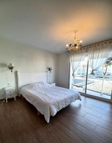 une chambre avec un lit et une grande fenêtre dans l'établissement L'Océan, à Mimizan