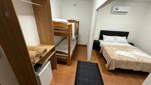 エンカルナシオンにあるEl Rodeo Hospedajeの小さな客室で、ベッド2台、二段ベッド1組が備わります。