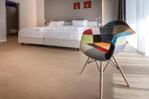 a colorful chair in a bedroom with a bed at Locanda Monte Baldo in Malcesine