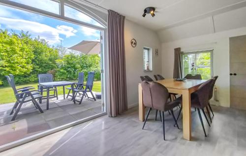 a dining room with a table and chairs and a patio at 3 Bedroom Gorgeous Home In Den Ham in Den Ham