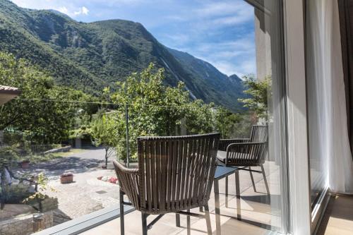 a balcony with chairs and a table with a view of mountains at Locanda Monte Baldo in Malcesine