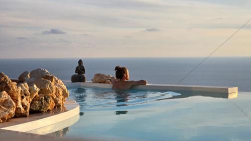 a woman in a swimming pool overlooking the ocean at Eunoia Porto Katsiki in Áyios Nikólaos Nirás