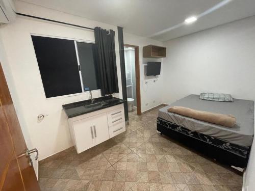 a bedroom with a bed and a sink and a mirror at Condomínio Residencial Vitória 3 in Sao Paulo