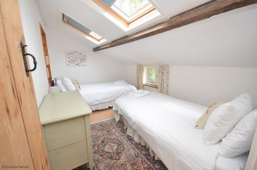 due letti in una stanza con lucernario di Wherry Cottage in Irstead on the Norfolk Broads a Neatishead