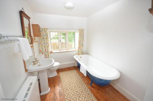 un bagno con lavandino, vasca e WC di Wherry Cottage in Irstead on the Norfolk Broads a Neatishead