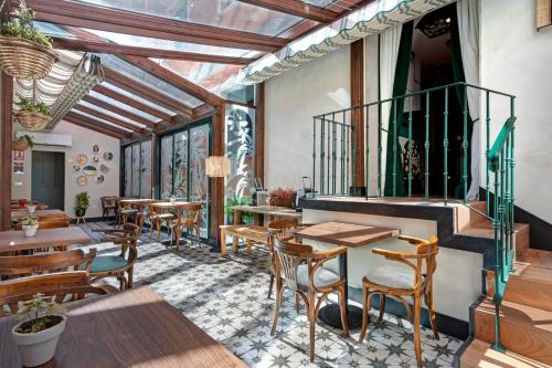 a restaurant with wooden tables and chairs and windows at Hospedium Hotel La Farm in La Granja de San Ildefonso