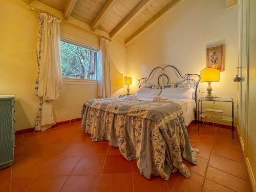 a bedroom with a bed and a window at Luxury Villa con Piscina & BBQ by Host Hero in Stintino