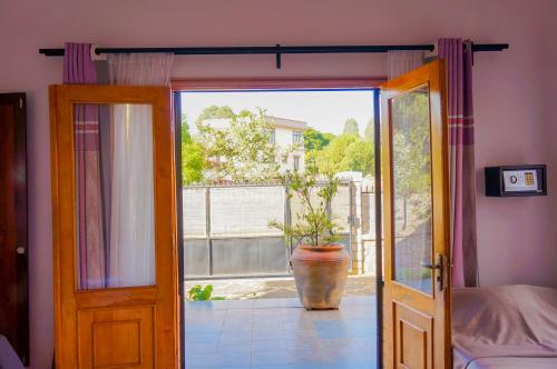 an open door to a room with a potted plant at Excellentia Antsirabe in Antsirabe