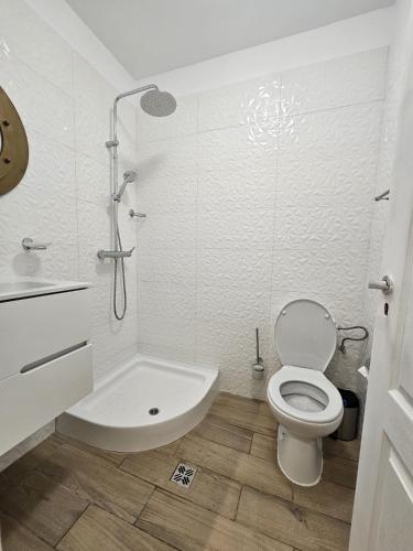 a white bathroom with a toilet and a shower at Sofia Residence in Constanţa