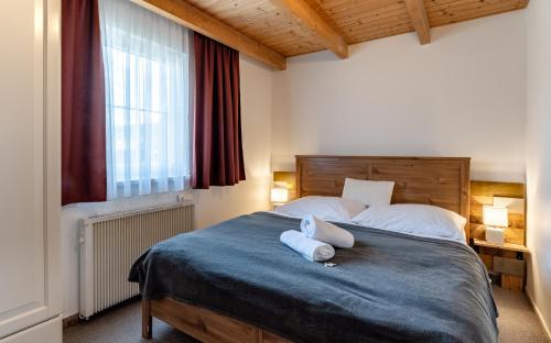 a bedroom with a bed with two towels on it at Rodinné apartmány Rafael Bedřichov in Bedřichov
