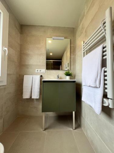 a bathroom with a green sink and a mirror at Iraipe Haro Auto Check-in in Haro