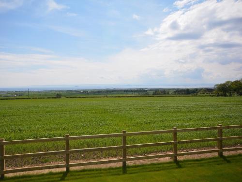 a wooden fence in front of a green field at 2 Bed in St Andrews 72435 in Anstruther