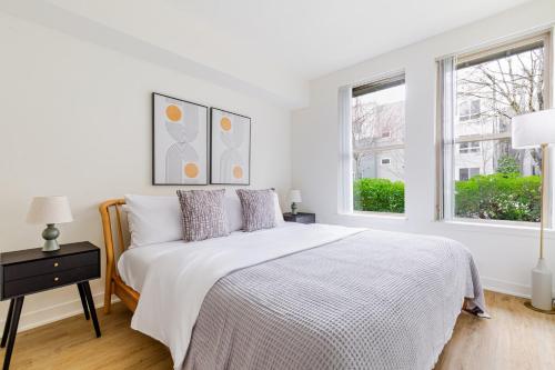 ein weißes Schlafzimmer mit einem Bett und zwei Fenstern in der Unterkunft Blueground NW Bellevue gym bbq nr park SEA-848 in Seattle