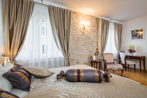 a bedroom with a bed with pillows on it at Priska Heritage Rooms in Split