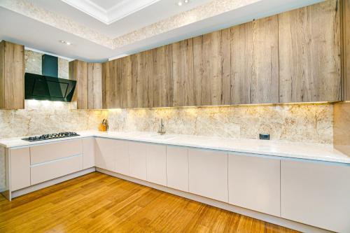 cocina con armarios blancos y paredes de madera en Luxury Apartments on Centre, en Baku