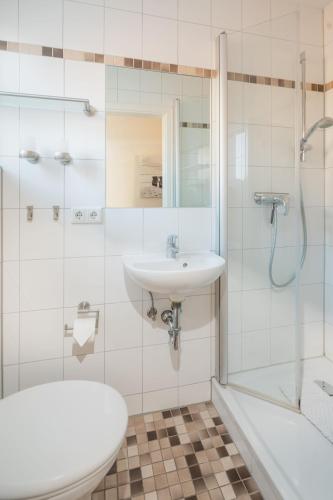 a bathroom with a sink and a shower and a toilet at Haus Juistine Süd in Juist