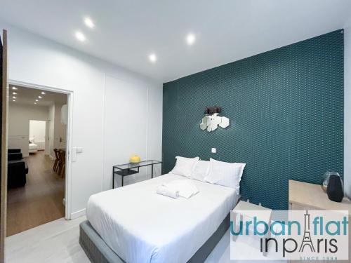 une chambre avec un lit blanc et un mur vert dans l'établissement Urban Flat 35 - 2 Bedroom Apartment Grands Boulevards, à Paris