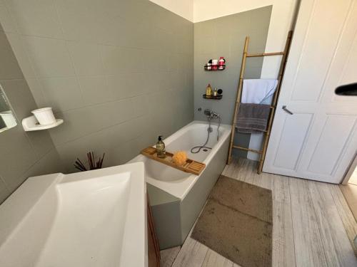 une salle de bain avec une baignoire blanche et un lavabo dans l'établissement Un paradis en provence, à Avignon