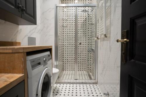 a bathroom with a shower and a washing machine at Cozy Urban 1BR Nest with Balcony Charm in Istanbul