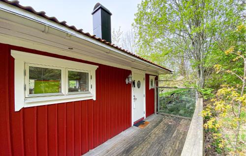 a red house with a white window and a deck at 1 Bedroom Lovely Home In Ulseröd in Ulseröd