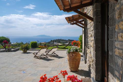 a patio with two chairs and a vase of flowers at Villa Mimì between Sorrento and Positano in Massa Lubrense