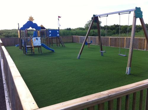 - une aire de jeux avec de l'herbe verte et des balançoires dans l'établissement Camping Mussonville, à Soulac-sur-Mer