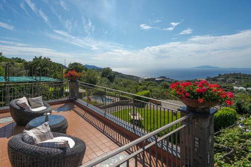 a balcony with two wicker chairs and flowers at Villa Mimì between Sorrento and Positano in Massa Lubrense