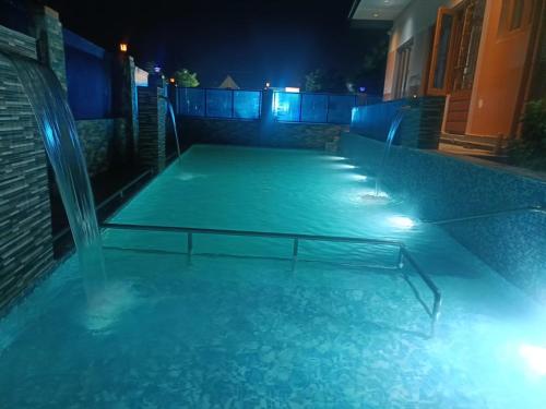 a swimming pool lit up at night with lights at Little Hearts in Chennai