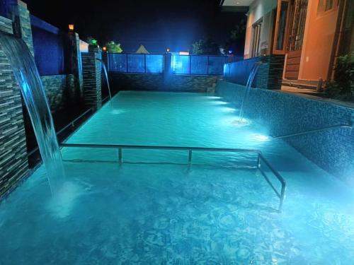 a swimming pool at night with a fountain at Little Hearts in Chennai