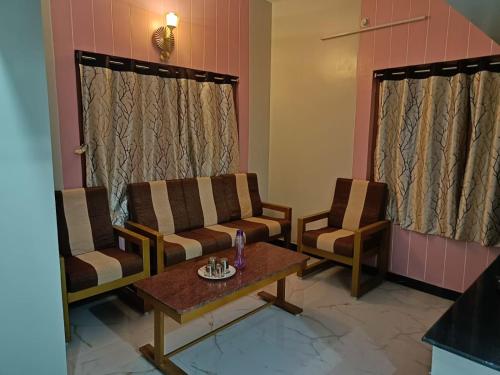 a living room with two chairs and a table at Little Hearts in Chennai