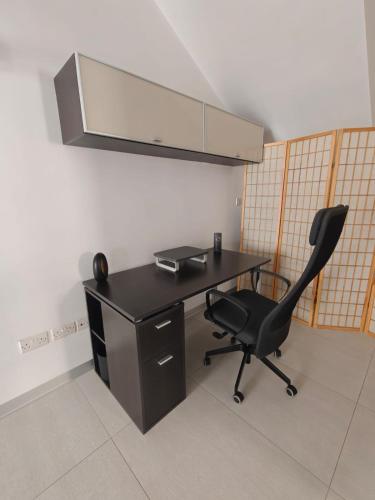 a black desk and a chair in a room at Ensuite Twin Room with Laundry in Pembroke in Pembroke 