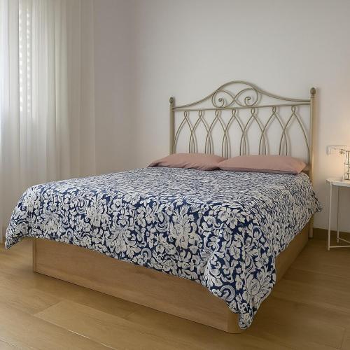 a bedroom with a bed with a blue and white bedspread at Céntrico Apartamento en Jaén 107 m2 2 baños 4 pax in Jaén