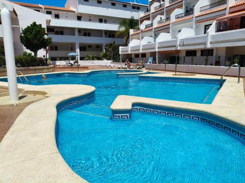 a swimming pool with blue water in a building at Cozy Ocean Park in Adeje