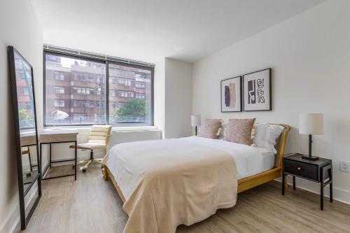 纽约Blueground LIC pool wd nr Gantry Park NYC-1845的一间卧室，配有一张床、一张书桌和一扇窗户