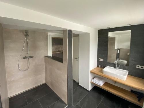 a bathroom with a sink and a shower at Rübenkämpers Ferienwohnungen in Schmallenberg