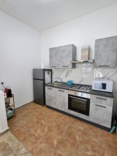 a kitchen with a stove and a microwave at Casa vacanze Stella in Silvi Marina