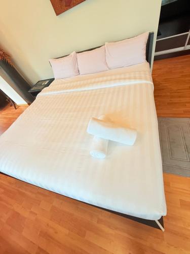 a bed with a white comforter with a bench on it at Park View Service Apartment By Kualalampur in Kuala Lumpur